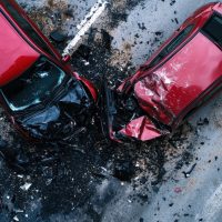 An aerial view of two red cars in a severe collision, depicting a chaotic scene that accentuates the serious nature of traffic accidents and the urgency for enhanced road safety.