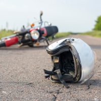 Photo of helmet and motorcycle on the road, the concept of road accidents