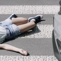 High angle on a child on a crosswalk hit by a car
