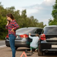 Male and female drivers on road, car accident