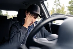 Tired man in car. Sleepy drowsy driver, fatigue. Driving and sleeping in vehicle. Exhausted, bored or drunk person. Serious upset man with stress, despair, anxiety or melancholy. Problem in traffic.